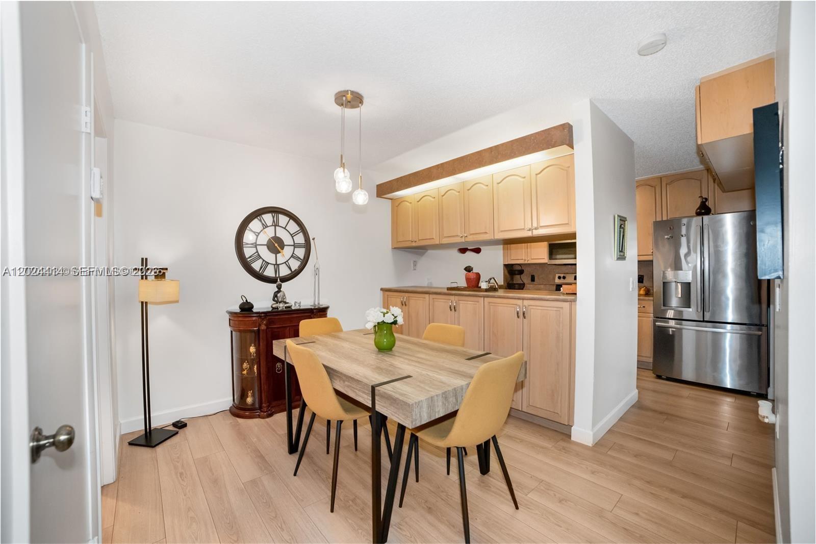 A dining area features a wooden table, yellow chairs, and light wood cabinetry — 9135 SW 20th Pl, Davie FL 33324, DAVIE, FL