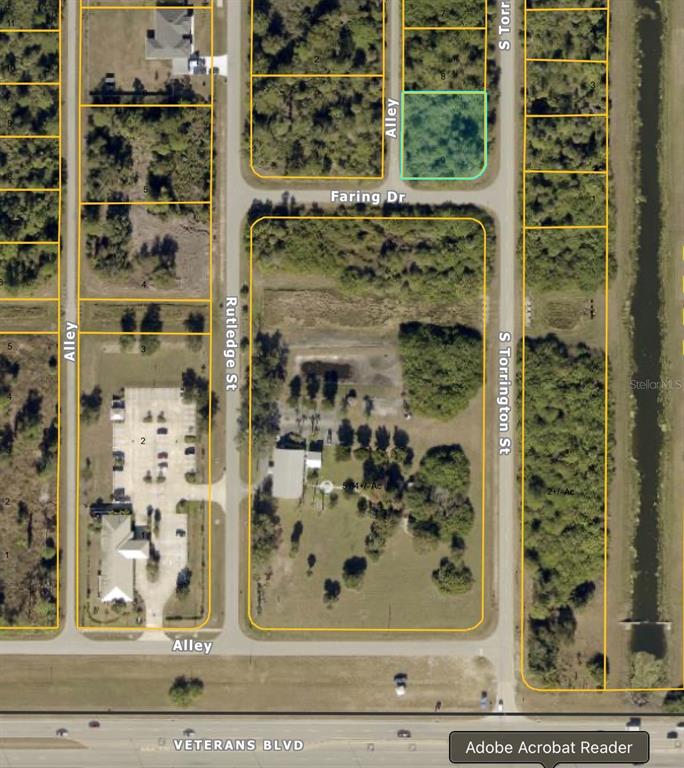 This aerial map shows a vacant lot highlighted in blue near residential streets and roads — S TORRINGTON STREET, NORTH PORT, FL