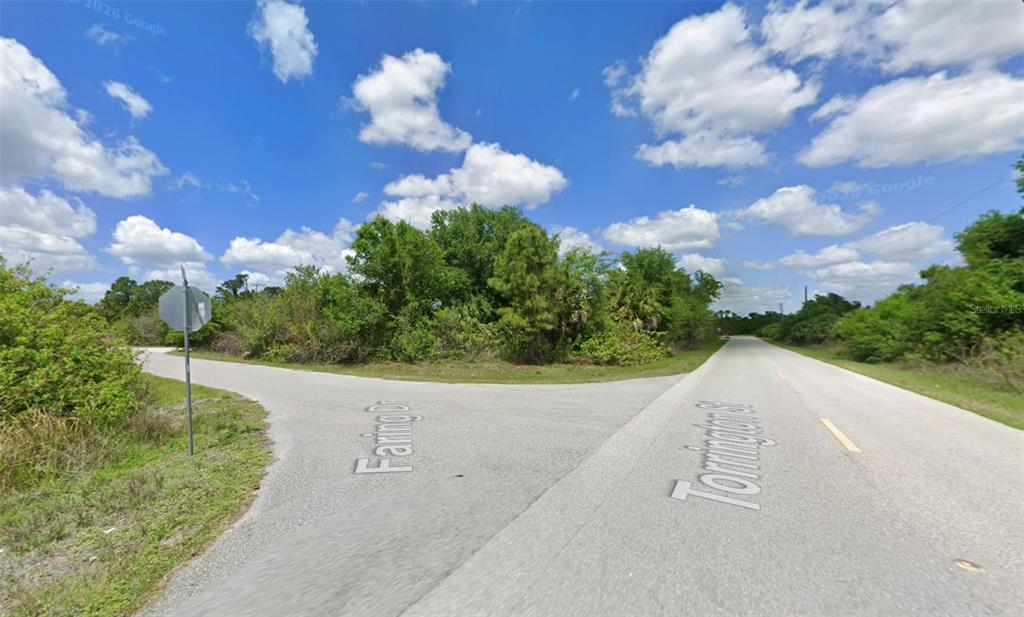 An outdoor view of a road intersection with a stop sign and surrounding vegetation — S TORRINGTON STREET, NORTH PORT, FL