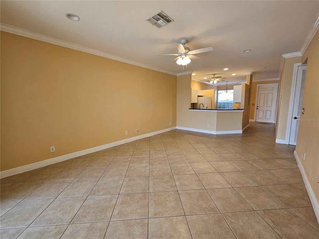 An open-concept living area features tan walls, tile flooring, and a kitchen with a breakfast bar — 231 CULTURAL PARK BOULEVARD S UNIT B, CAPE CORAL, FL