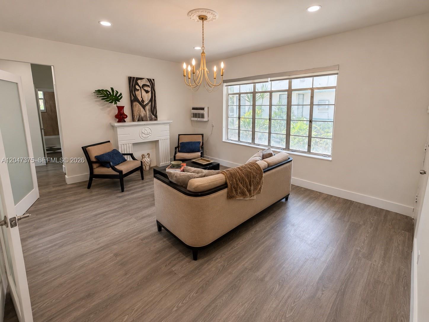 A living room features a fireplace, a sofa, two armchairs, and large windows — 762 Lenox Ave # 2, Miami Beach FL 33139, MIAMI BEACH, FL