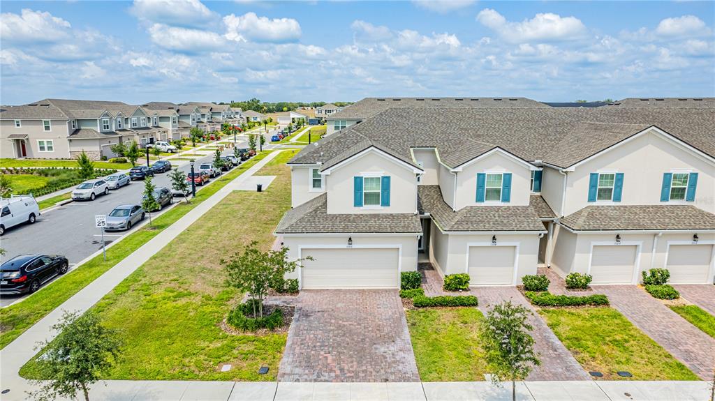 An aerial view of a multi-unit townhouse complex with brick driveways and attached garages — 1100 LAKESHORE BREEZE PLACE, KISSIMMEE, FL