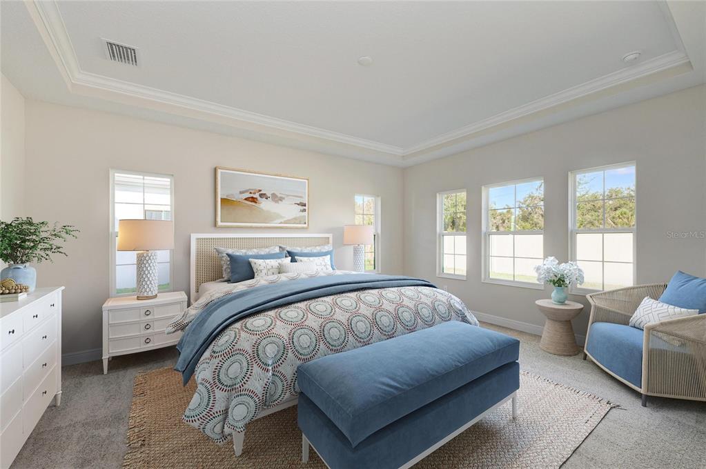 A bedroom features a bed with blue bedding, a bench, and a chair on carpet — 13068 HOMESTEAD LANE, PARRISH, FL