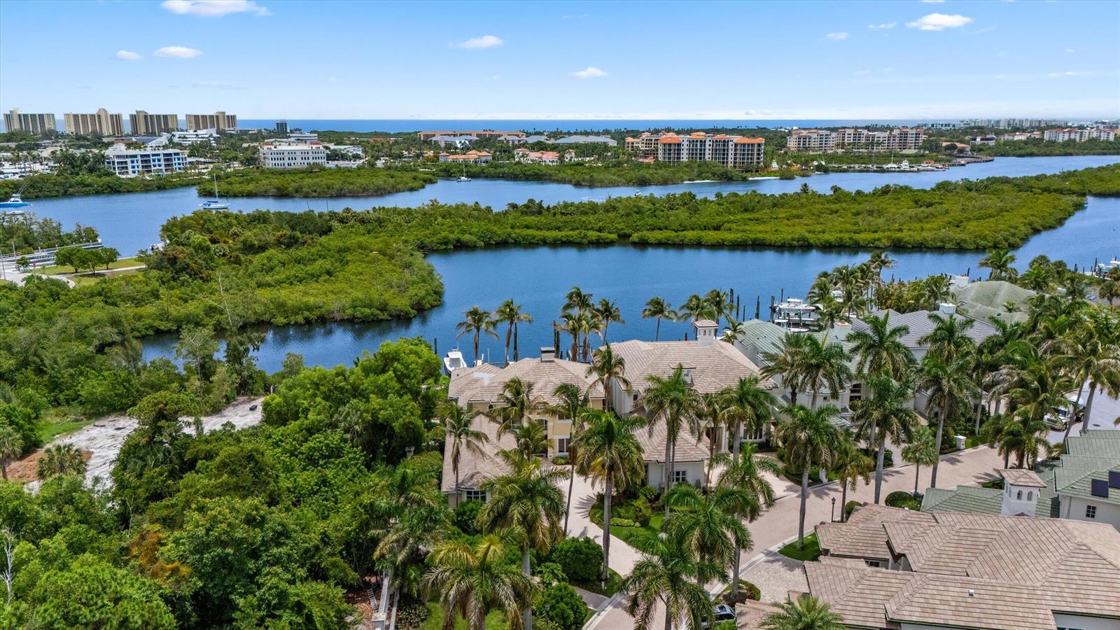 An aerial view shows a waterfront estate surrounded by lush trees, palm trees, and waterways — 3551 Jonathans Harbour Drive, Jupiter FL 33477, JUPITER, FL
