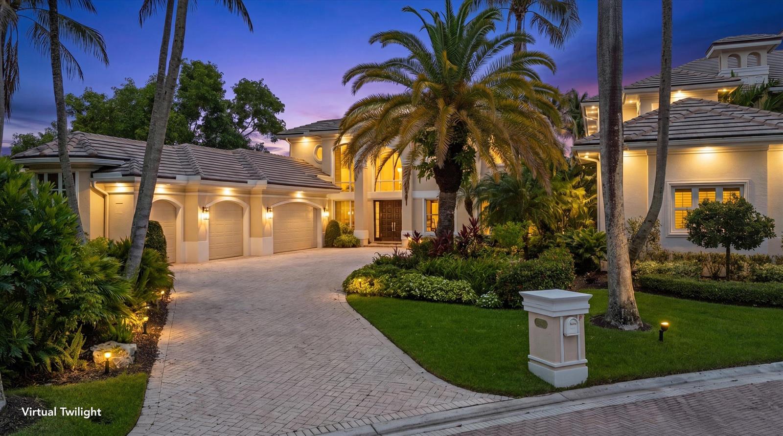 A two-story house with a paved driveway, three-car garage, and palm trees at twilight — 3551 Jonathans Harbour Drive, Jupiter FL 33477, JUPITER, FL