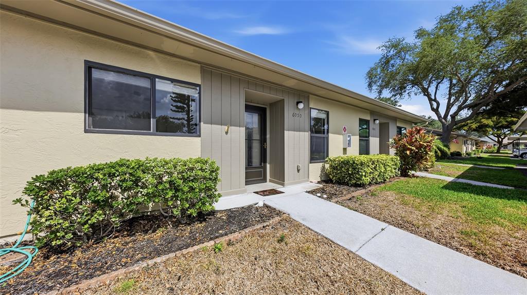 A single-story building exterior features a beige facade, a front entrance, and a concrete walkway — 6050 28TH STREET W, BRADENTON, FL