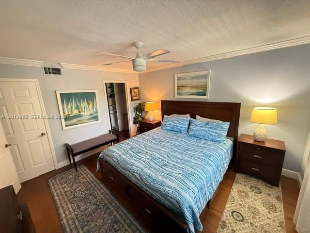 A bedroom features a bed with blue patterned bedding, two nightstands, and a ceiling fan — 275 Palm Ave # A205, Jupiter FL 33477, JUPITER, FL