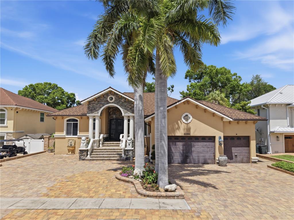 A single-story house with a stone-accented entrance, palm trees, and a paved driveway — 8286 N 97TH N ST, SEMINOLE, FL