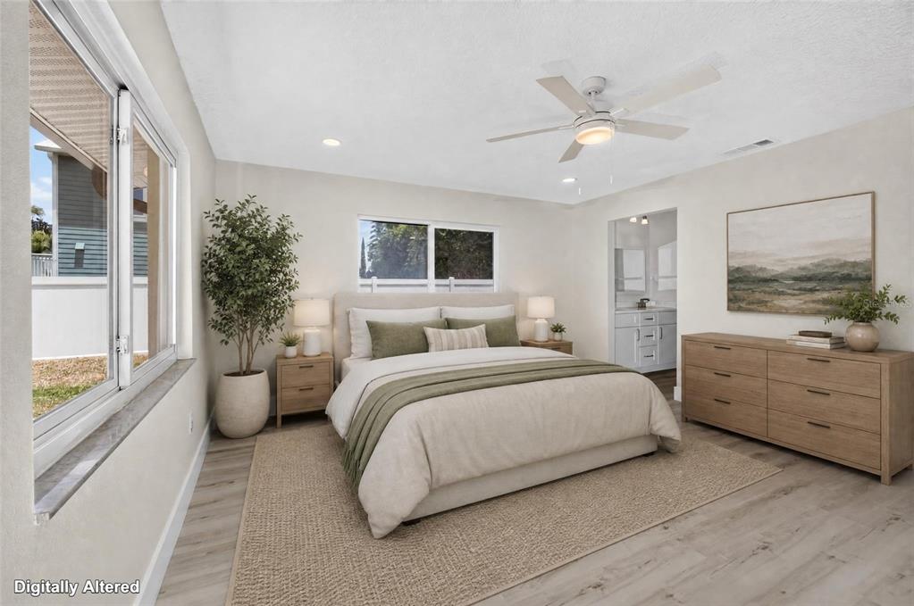 This digitally altered bedroom features a queen bed, light wood furniture, and a ceiling fan — 1225 HOFFNER AVENUE, ORLANDO, FL