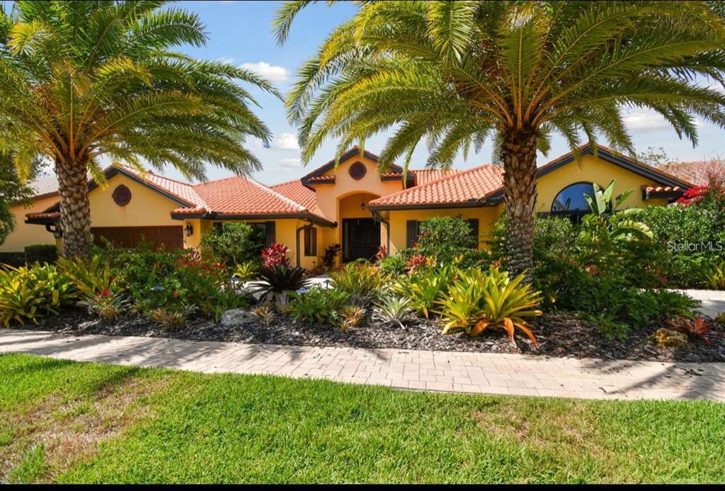 A yellow single-story house with a red tile roof and palm trees in the front — 9805 COMPASS POINT WAY, TAMPA, FL