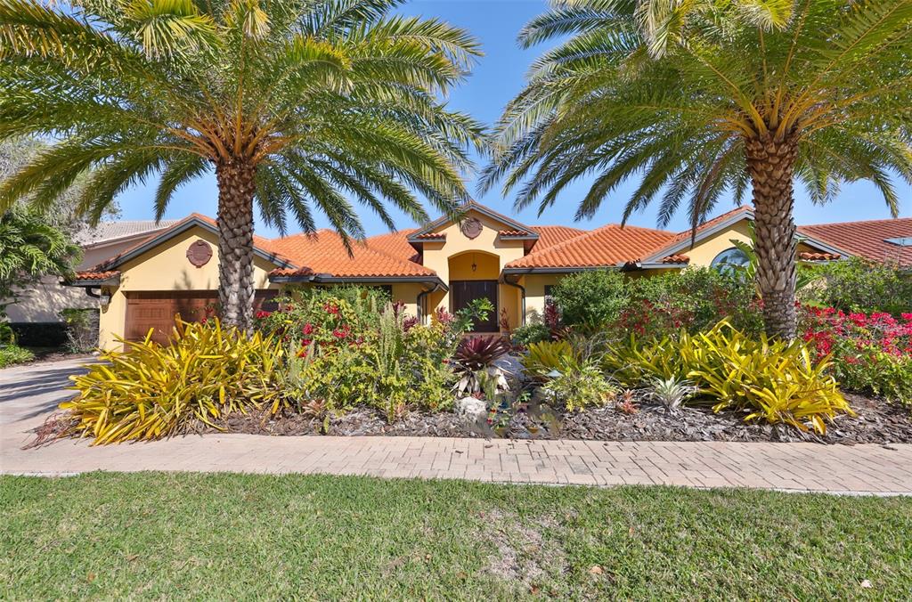 A single-story house with a tile roof and palm trees in front of the entrance — 9805 COMPASS POINT WAY, TAMPA, FL