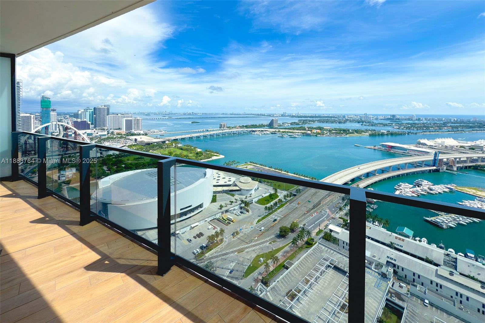 A high-rise balcony with glass railings overlooks the Miami skyline, bay, and bridge — 398 NE 5th St # 2410, Miami FL 33132, MIAMI, FL