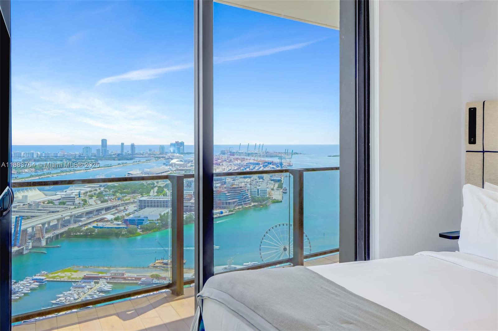 A bedroom features a floor-to-ceiling window with a view of a harbor and city — 398 NE 5th St # 2410, Miami FL 33132, MIAMI, FL