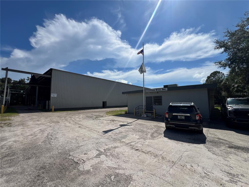 An exterior view of a commercial building with a metal warehouse and a small office — 5101 24TH AVENUE S, TAMPA, FL