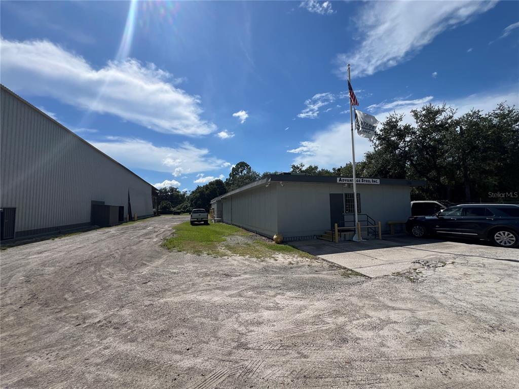 An exterior view of a commercial building with a gravel lot and a flagpole — 5101 24TH AVENUE S, TAMPA, FL