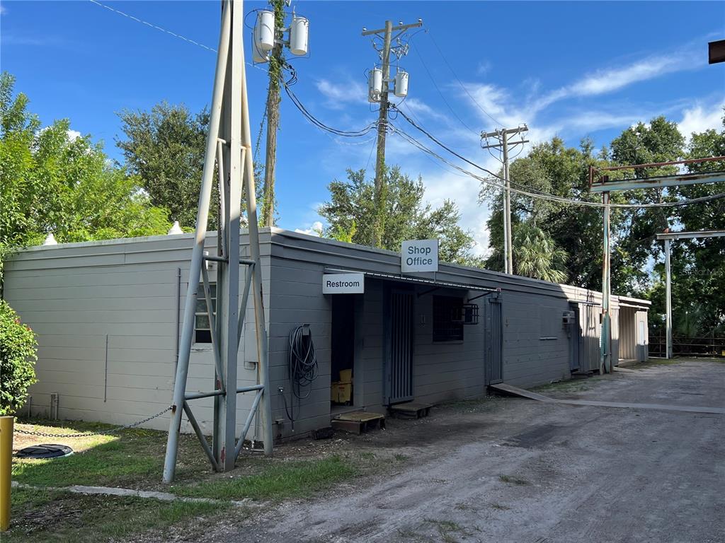 A gray, single-story concrete block building features a shop office and a restroom entrance — 5101 24TH AVENUE S, TAMPA, FL