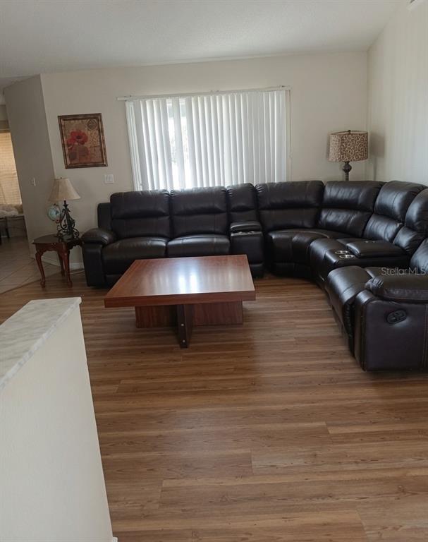 A living room features a large brown leather sectional, a wooden coffee table, and flooring — 16705 SW 22ND TERRACE ROAD, OCALA, FL