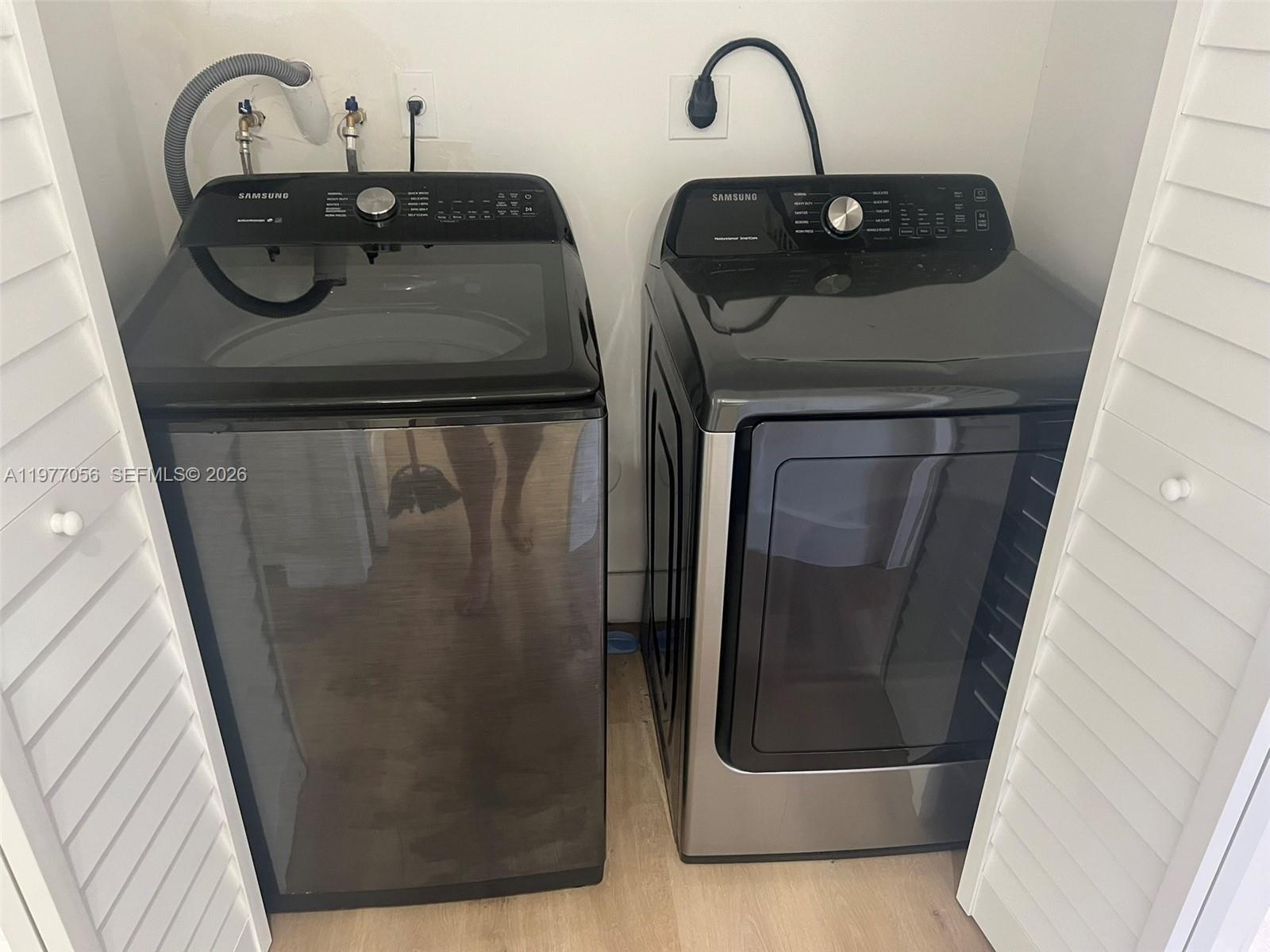 A laundry closet contains a black Samsung top-load washing machine and a matching dryer — 2511 NE 41st Ter, Homestead FL 33033, HOMESTEAD, FL