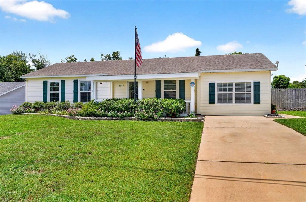A single-story house with light yellow siding, green shutters, and a concrete driveway — 3018 YORKSHIRE DRIVE, DELTONA, FL