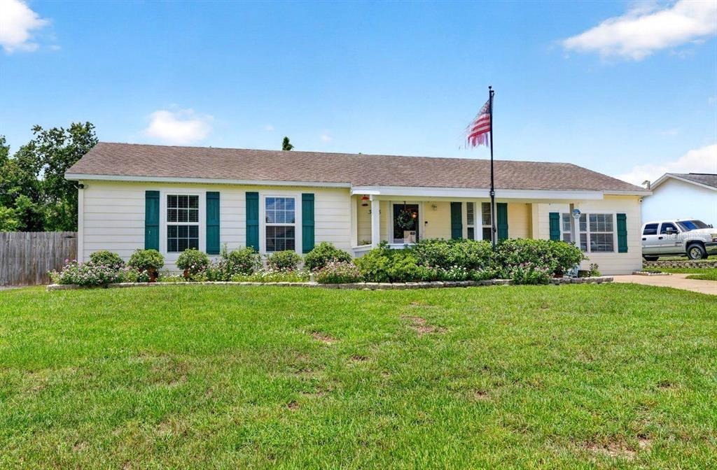A single-story house with light yellow siding, green shutters, and a front lawn — 3018 YORKSHIRE DRIVE, DELTONA, FL