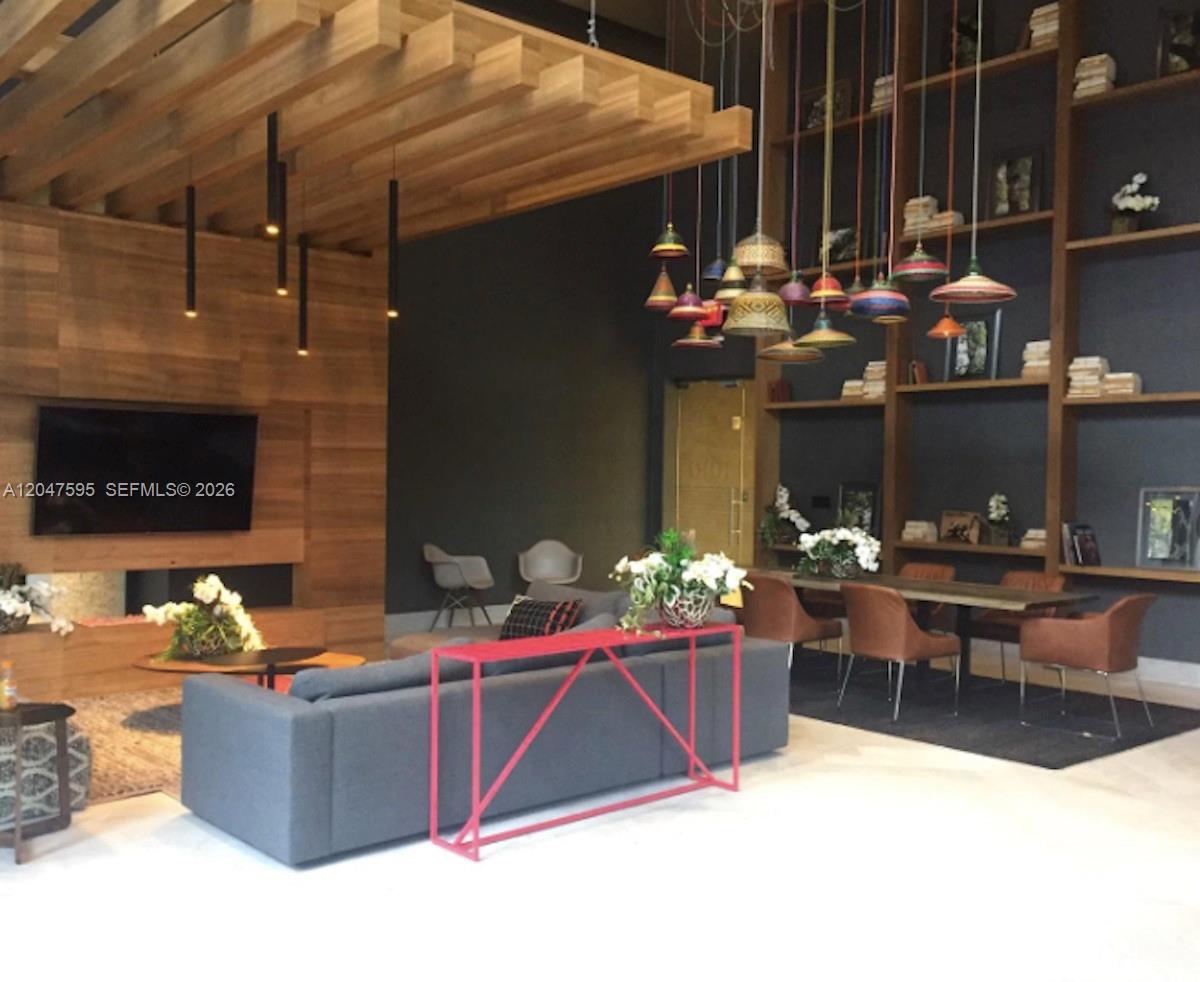 A modern living and dining area features a wood-slatted ceiling, pendant lights, and shelving — 1010 Brickell Ave # 3709, Miami FL 33131, MIAMI, FL