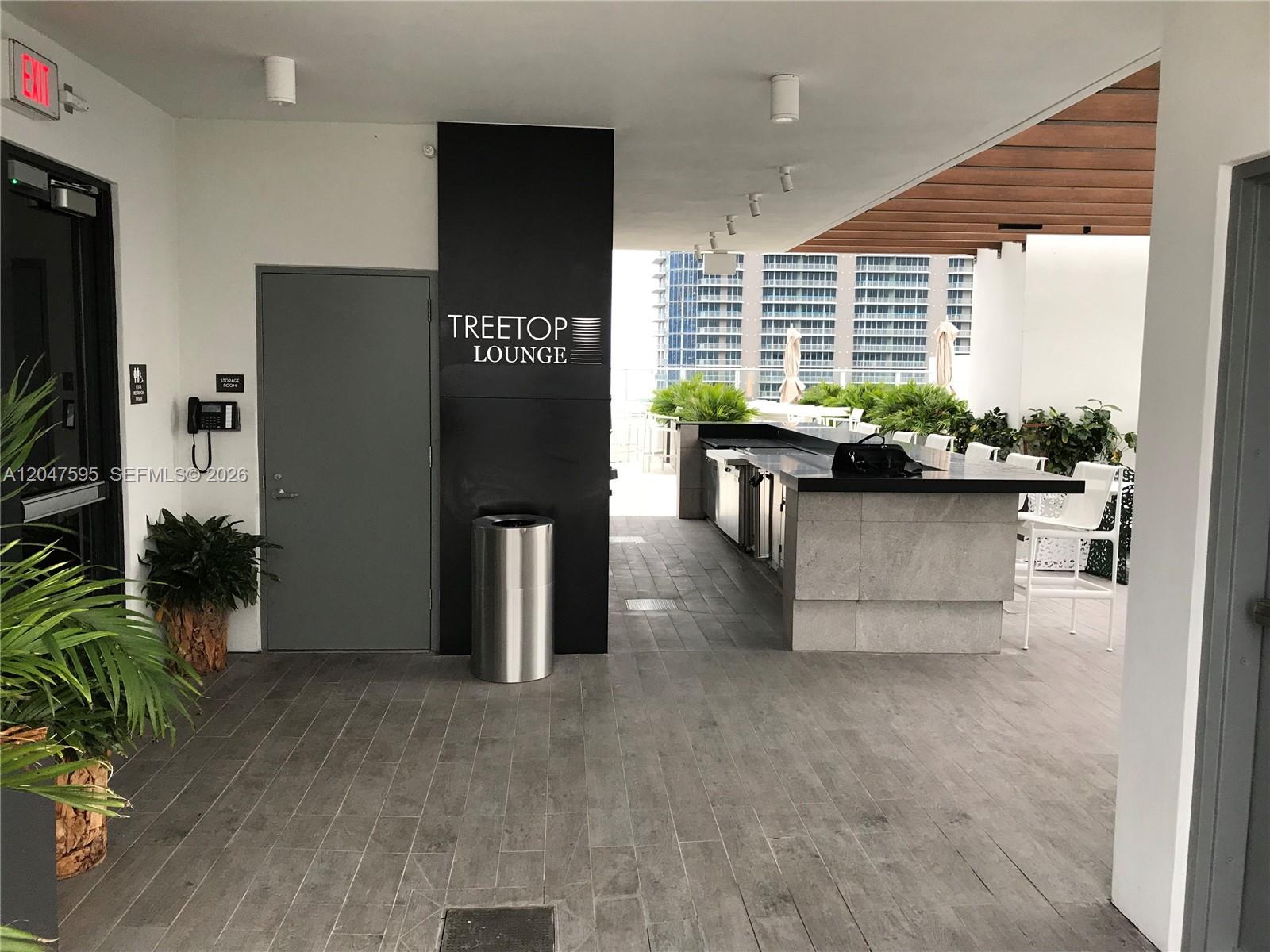 An outdoor lounge area features a bar, seating, and a sign labeled Treetop Lounge — 1010 Brickell Ave # 3709, Miami FL 33131, MIAMI, FL