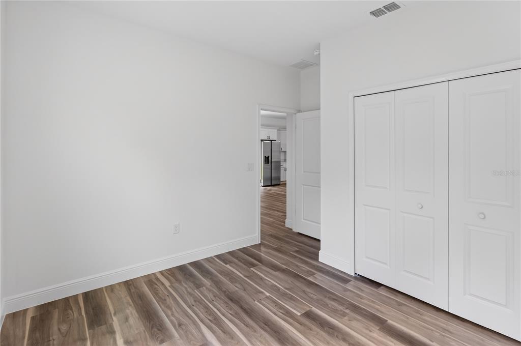A room with white walls, wood-look flooring, and a white bi-fold closet door — 9066 N AKOLA WAY, CITRUS SPRINGS, FL