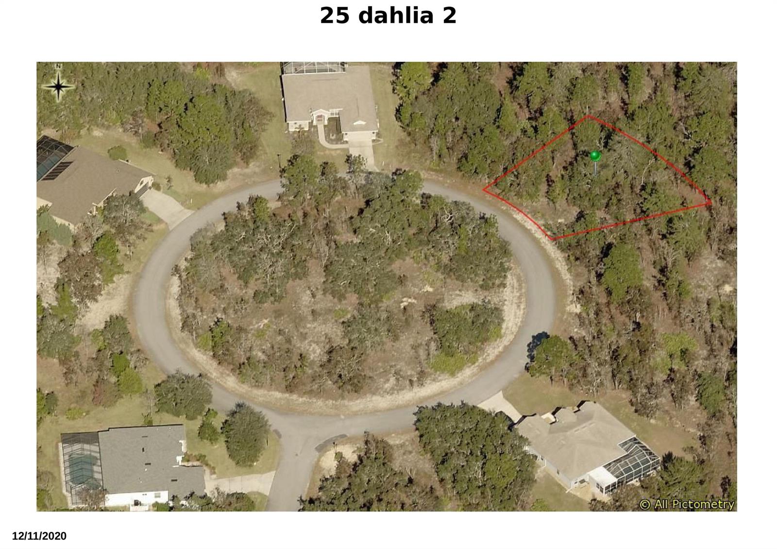 An aerial view shows a vacant, wooded lot outlined in red next to a circular road — 25 Dahlia Court N, FL 34446, FL