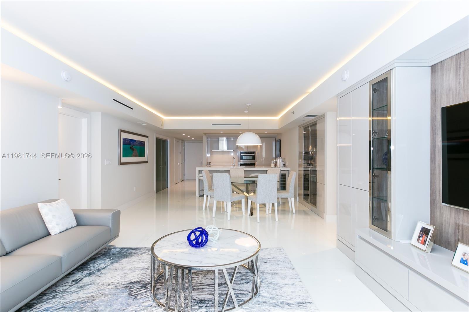 A modern, open-concept living and dining area features white tile floors and minimalist decor — 1830 S Ocean Dr # 2903, Hallandale Beach FL 33009, HALLANDALE BEACH, FL