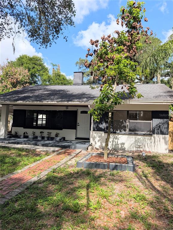 A single-story house with a carport and a chain-link fence under large oak trees — 8206 N 19TH STREET, TAMPA, FL