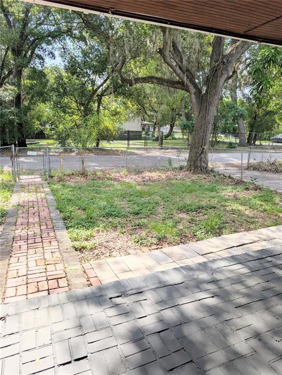 A single-story house with a brick walkway, a front porch, and a small tree — 8206 N 19TH STREET, TAMPA, FL