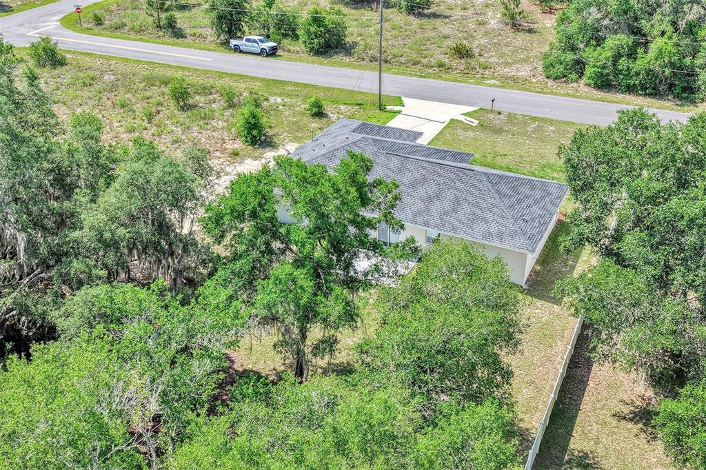 An aerial view shows a single-story house with a gray roof surrounded by trees — 5 LOCUST RADIAL CIRCLE, OCALA, FL