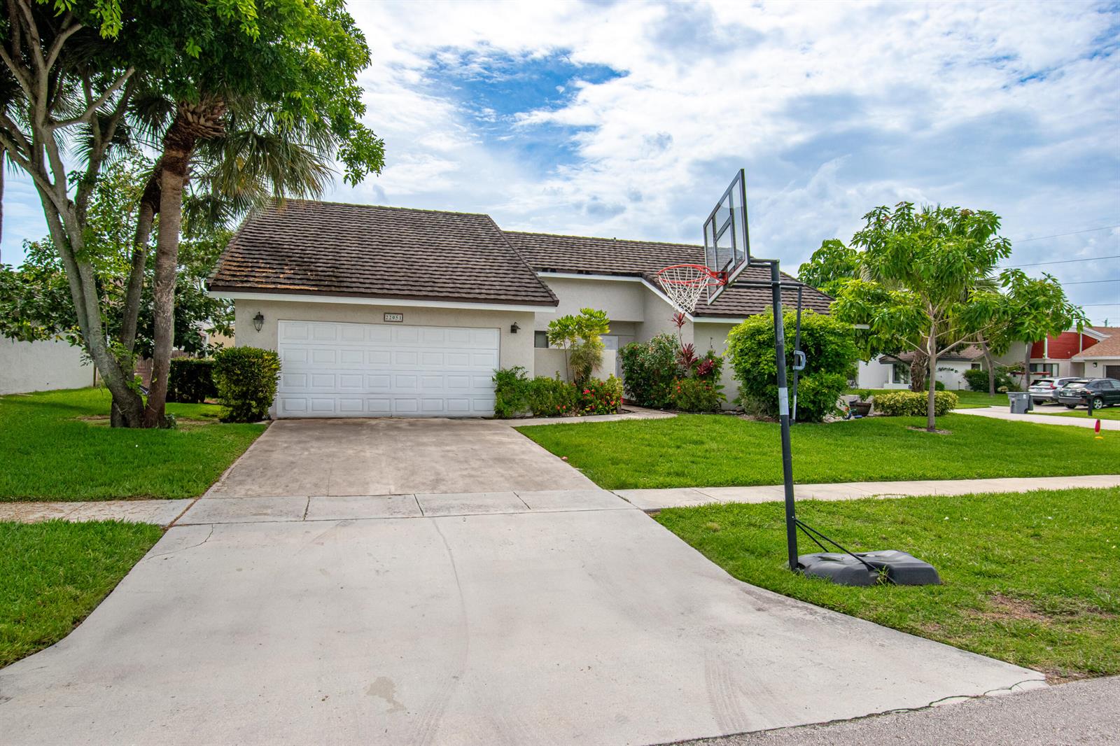 A single-story house with a two-car garage, a driveway, and a basketball hoop — 22051 Montoya Drive, Boca Raton FL 33433, BOCA RATON, FL