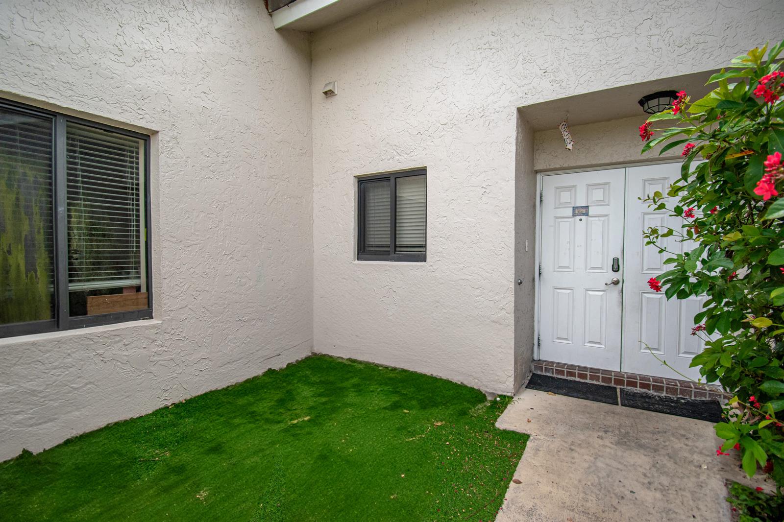 A small patch of artificial grass sits in front of a white building with double doors — 22051 Montoya Drive, Boca Raton FL 33433, BOCA RATON, FL