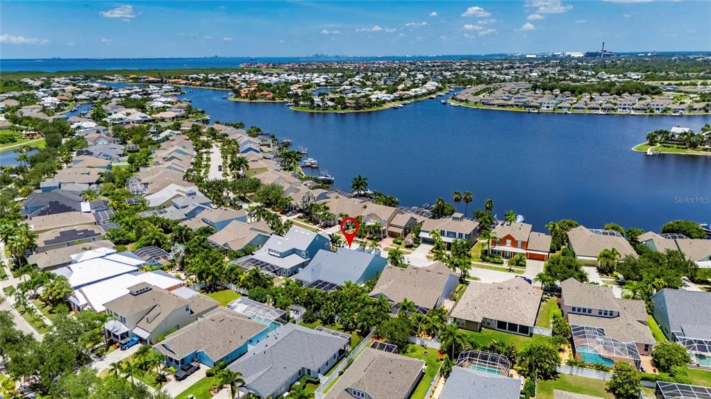 This is an aerial view of a residential neighborhood featuring houses with pools near a lake — 5226 BRIGHTON SHORE DRIVE, APOLLO BEACH, FL