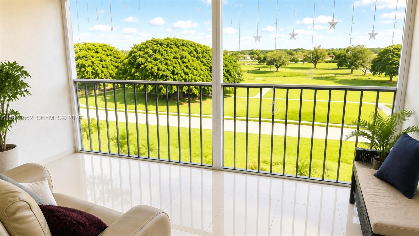 A balcony with tile flooring, a sofa, and a view of a grassy golf course — 4570 NW 18th Ave # 506, Deerfield Beach FL 33064, DEERFIELD BEACH, FL