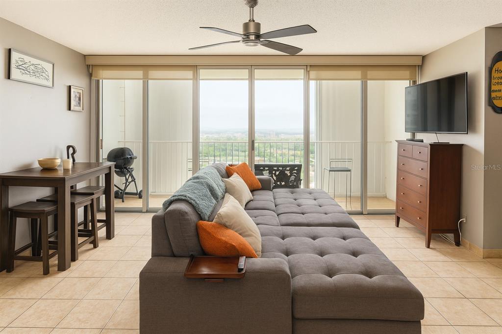 A living room features a gray tufted sectional, a dining table, and a balcony view — 3103 AVE. ISLA VERDE COND. CONDESA DEL MAR UNIT 1402, ISLA VERDE, PR