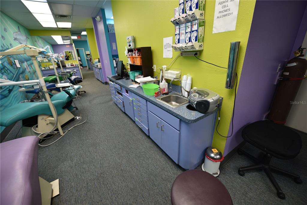 A dental office features multiple patient chairs, a blue cabinet workstation, and bright green walls — 5124 US HIGHWAY 19 UNIT 5120, NEW PORT RICHEY, FL