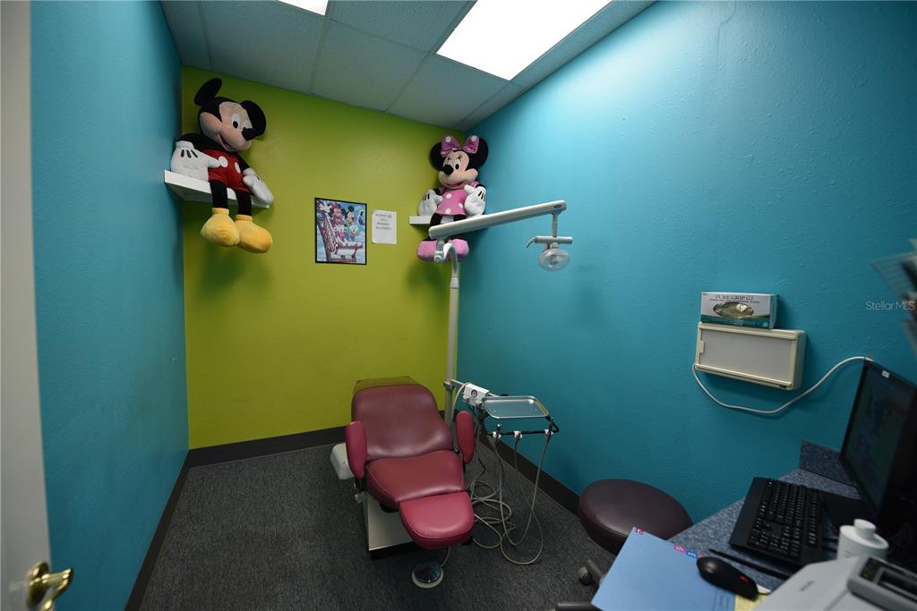 A pediatric dental exam room features a pink chair, Mickey and Minnie Mouse plush toys, and colorful walls — 5124 US HIGHWAY 19 UNIT 5120, NEW PORT RICHEY, FL
