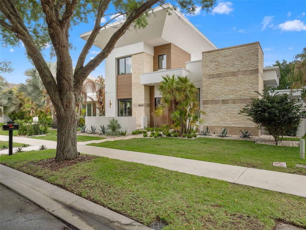A modern house exterior features a rectangular swimming pool with an attached spa and patio — 8643 FARTHINGTON WAY, ORLANDO, FL