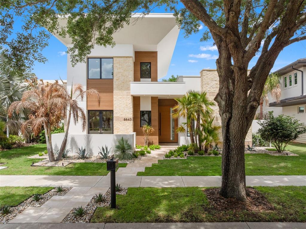 A modern backyard features a rectangular swimming pool with fountains and a raised spa — 8643 FARTHINGTON WAY, ORLANDO, FL
