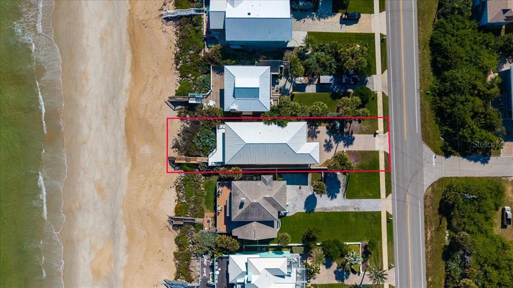 A yellow two-story house with a paved driveway and two garage doors — 5609 S ATLANTIC AVENUE, NEW SMYRNA BEACH, FL