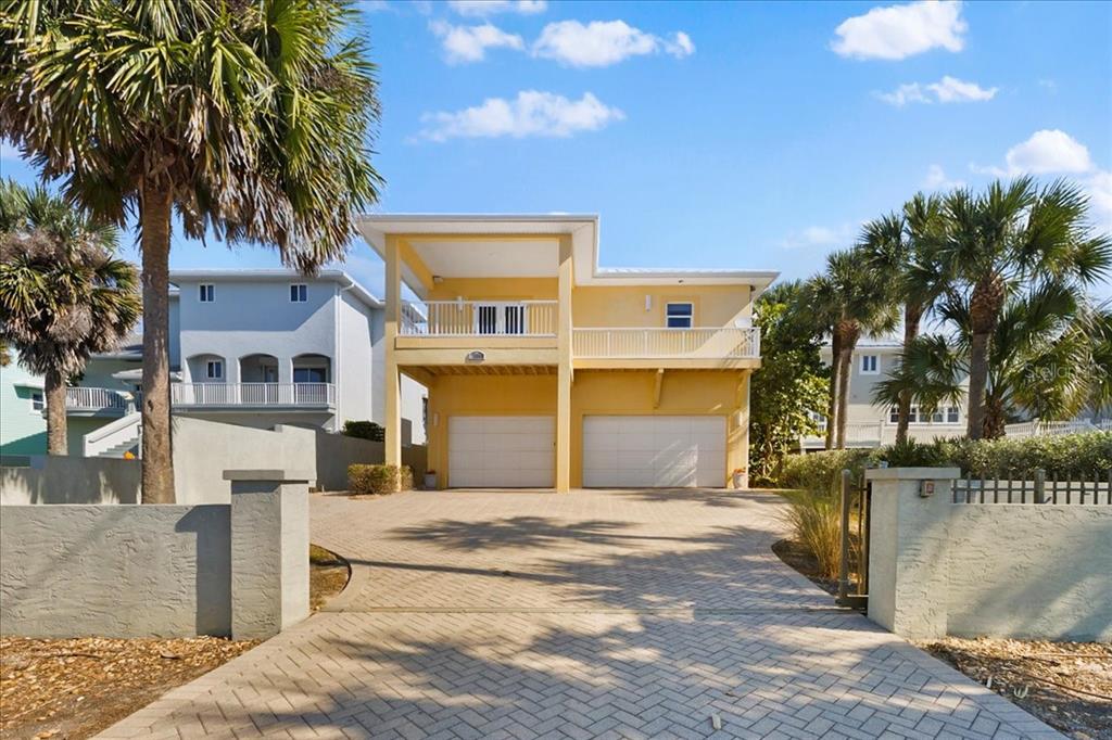 A white wooden deck overlooks a sandy beach and the ocean under a blue sky — 5609 S ATLANTIC AVENUE, NEW SMYRNA BEACH, FL