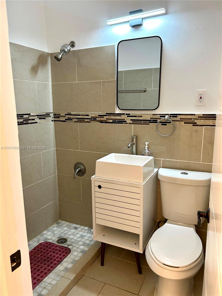 A small bathroom features a walk-in shower, a vessel sink vanity, and a toilet — 215 30th St # 17, Miami Beach FL 33140, MIAMI BEACH, FL