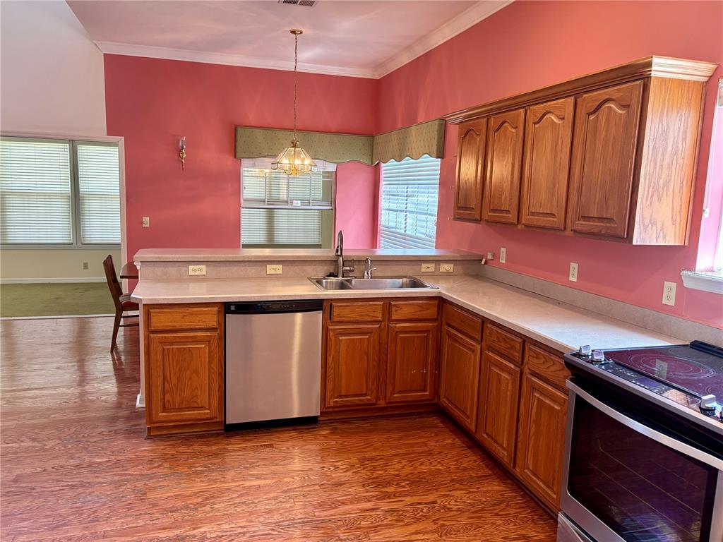 A kitchen features wood cabinets, stainless steel appliances, a sink, and pink walls — 10961 PALMETTO BOULEVARD, ALACHUA, FL