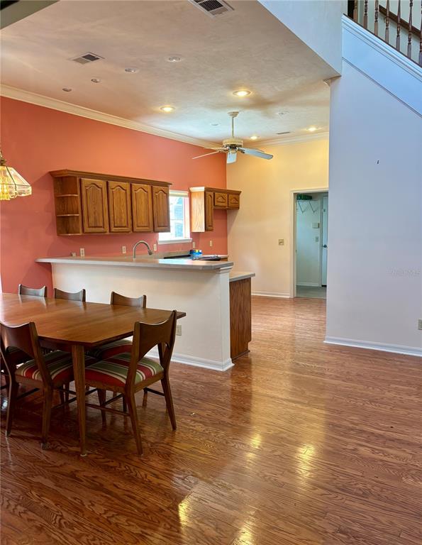 A dining area with a wooden table and chairs sits before an open kitchen — 10961 PALMETTO BOULEVARD, ALACHUA, FL