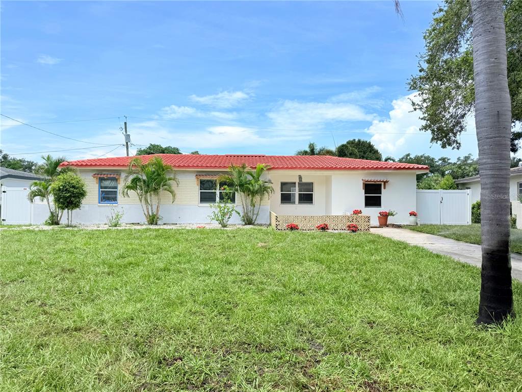 A single-story house with a red tile roof and a front lawn with palm trees — 1500 77TH STREET N, ST PETERSBURG, FL