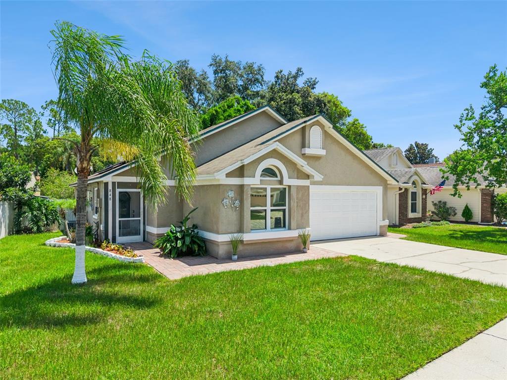 A single-story house with a beige stucco exterior, a white garage door, and a palm tree — 848 HEATHER GLEN CIRCLE, LAKE MARY, FL
