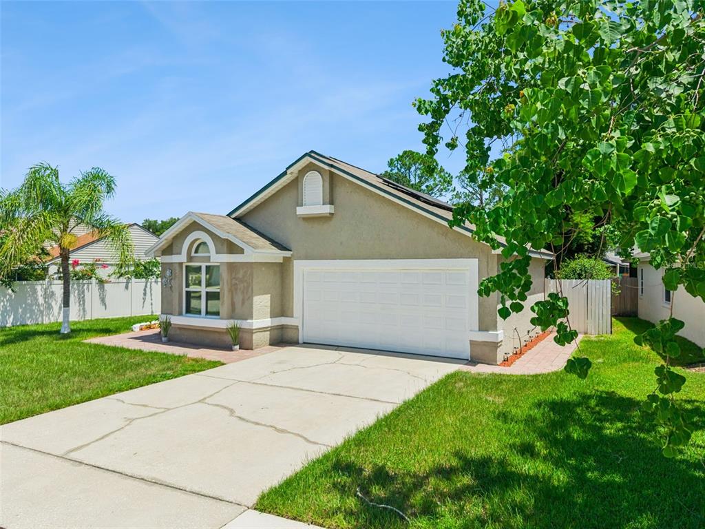 A single-story house with a beige stucco exterior, a white garage door, and a front lawn — 848 HEATHER GLEN CIRCLE, LAKE MARY, FL