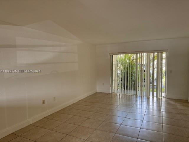 An empty room with white walls, tile flooring, and a sliding glass door — 7350 SW 82nd St # C125, Miami FL 33143, MIAMI, FL